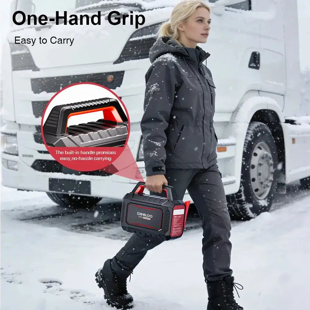 Moteris nešanti GOOLOO GT TRUCK PLUS sunkiasvorių transporto priemonių užvedėją sniege su patogia rankena.